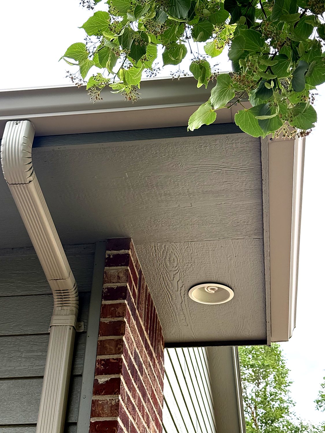 Gutter corner and downspout at a brick column