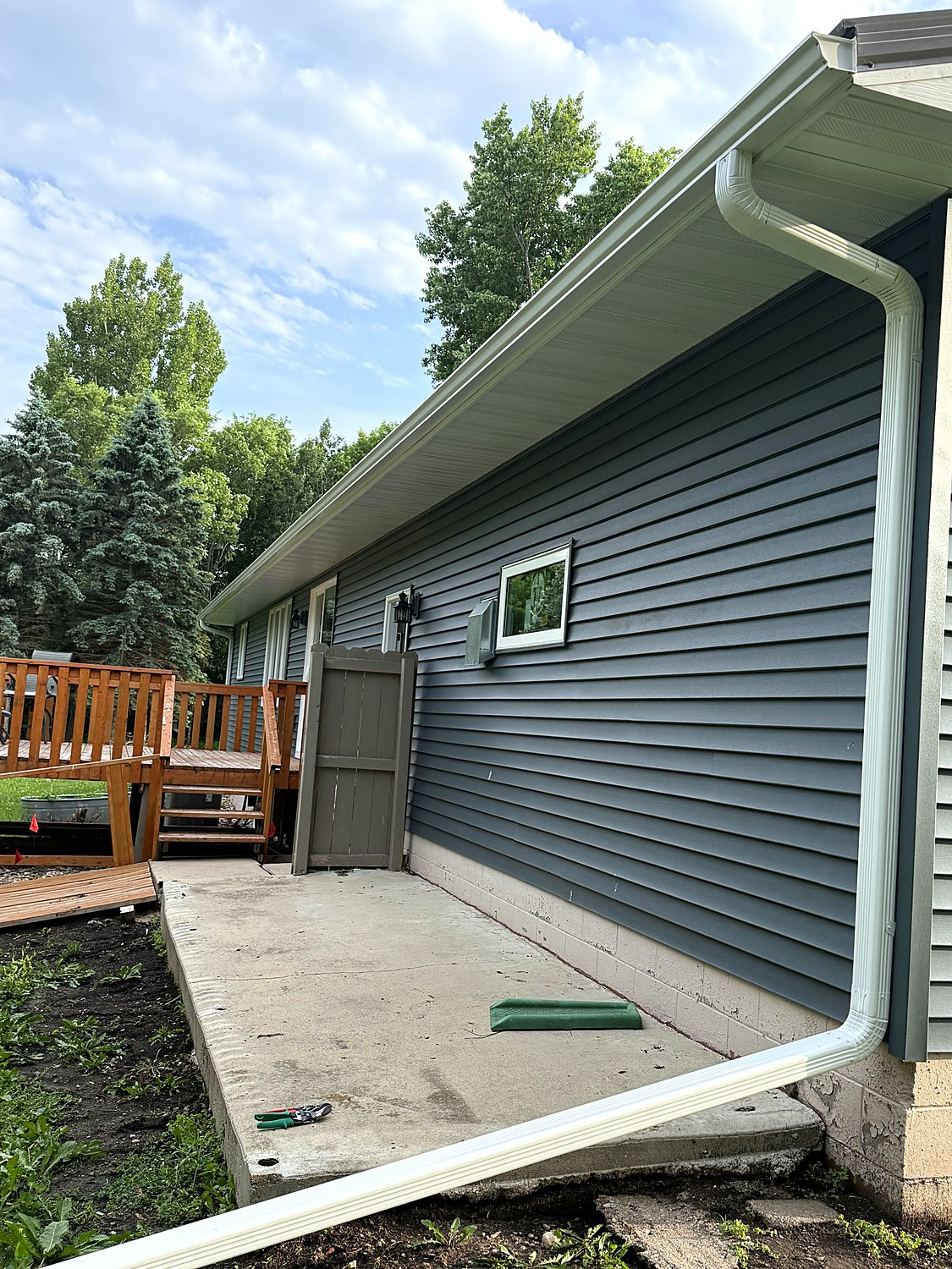 Seamless gutter and downspout along a lap-siding home